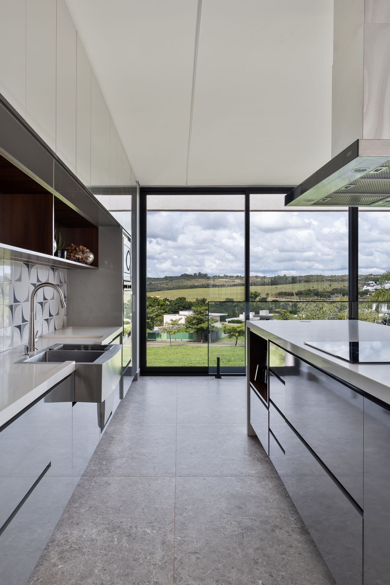 Corredor da cozinha com ilha e janela do piso ao teto para a paisagem