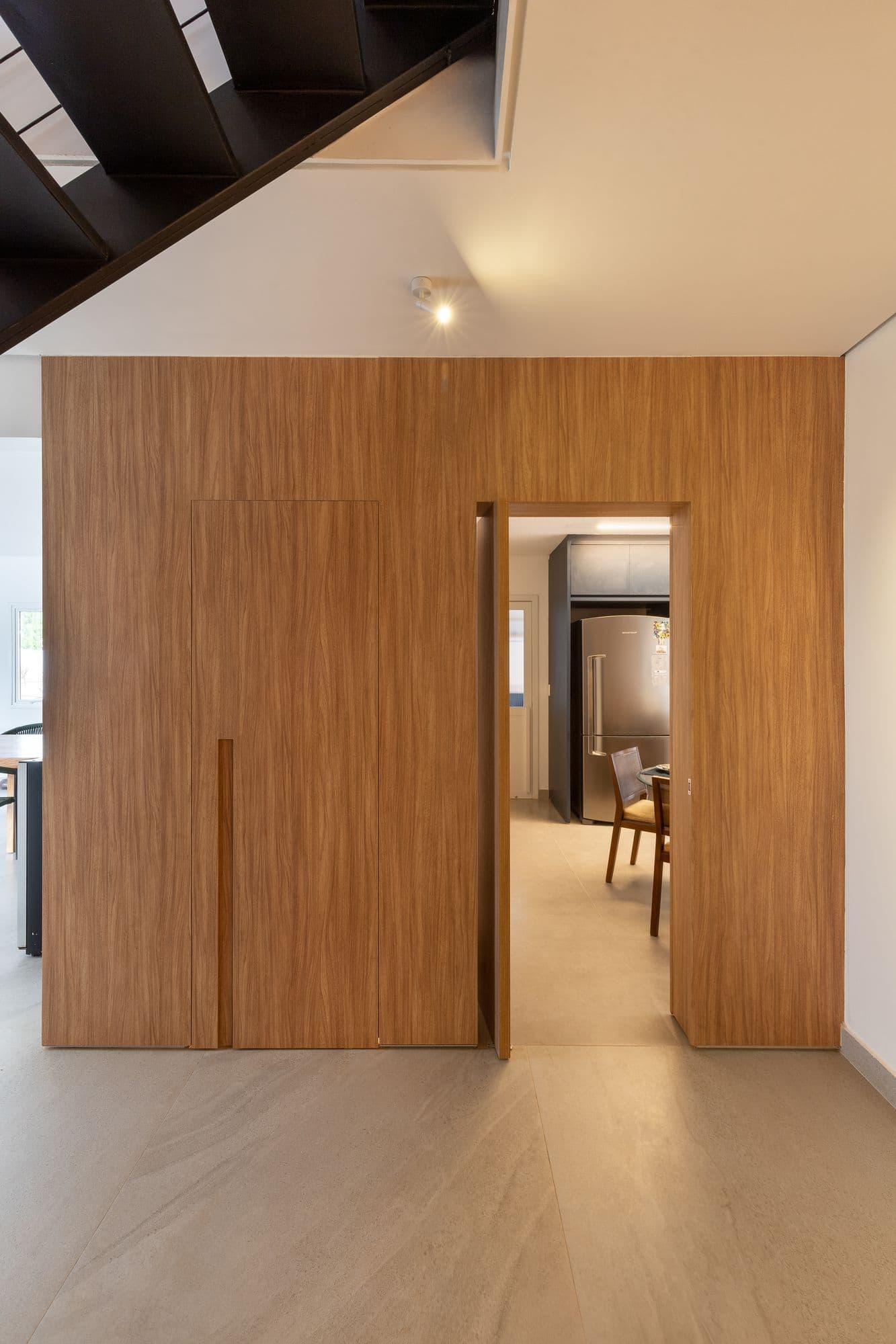 Painel de madeira do piso ao teto com uma porta oculta que se abre para a cozinha, em casa no Lago Norte