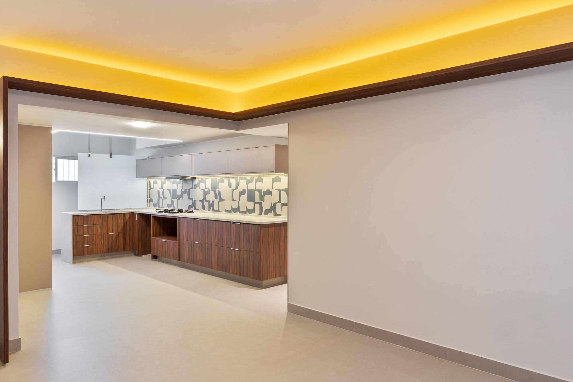 Sala com moldura de madeira e iluminação indireta aberta para a cozinha