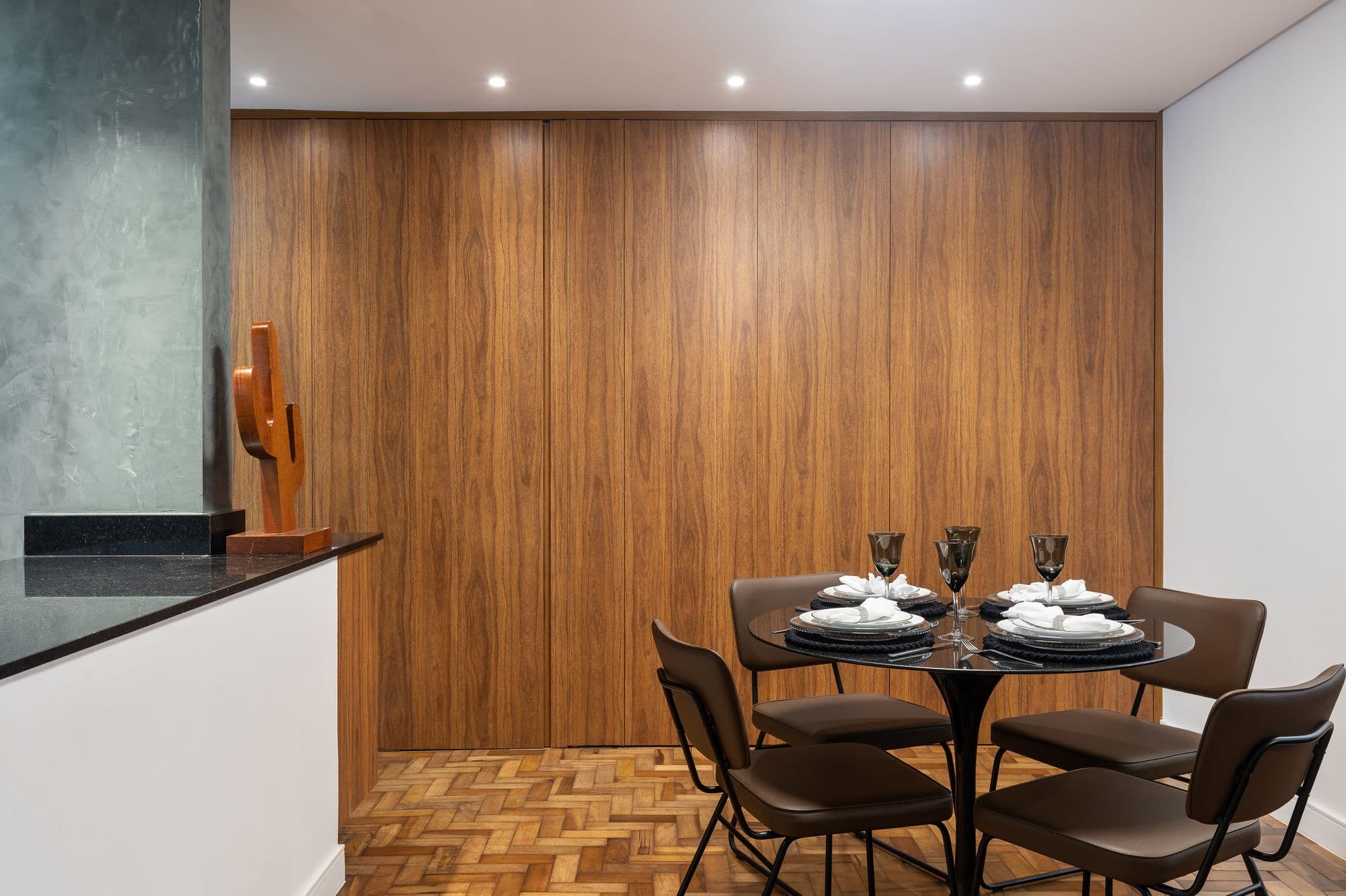 Sala de jantar com o painel de madeira fechado e piso de taco