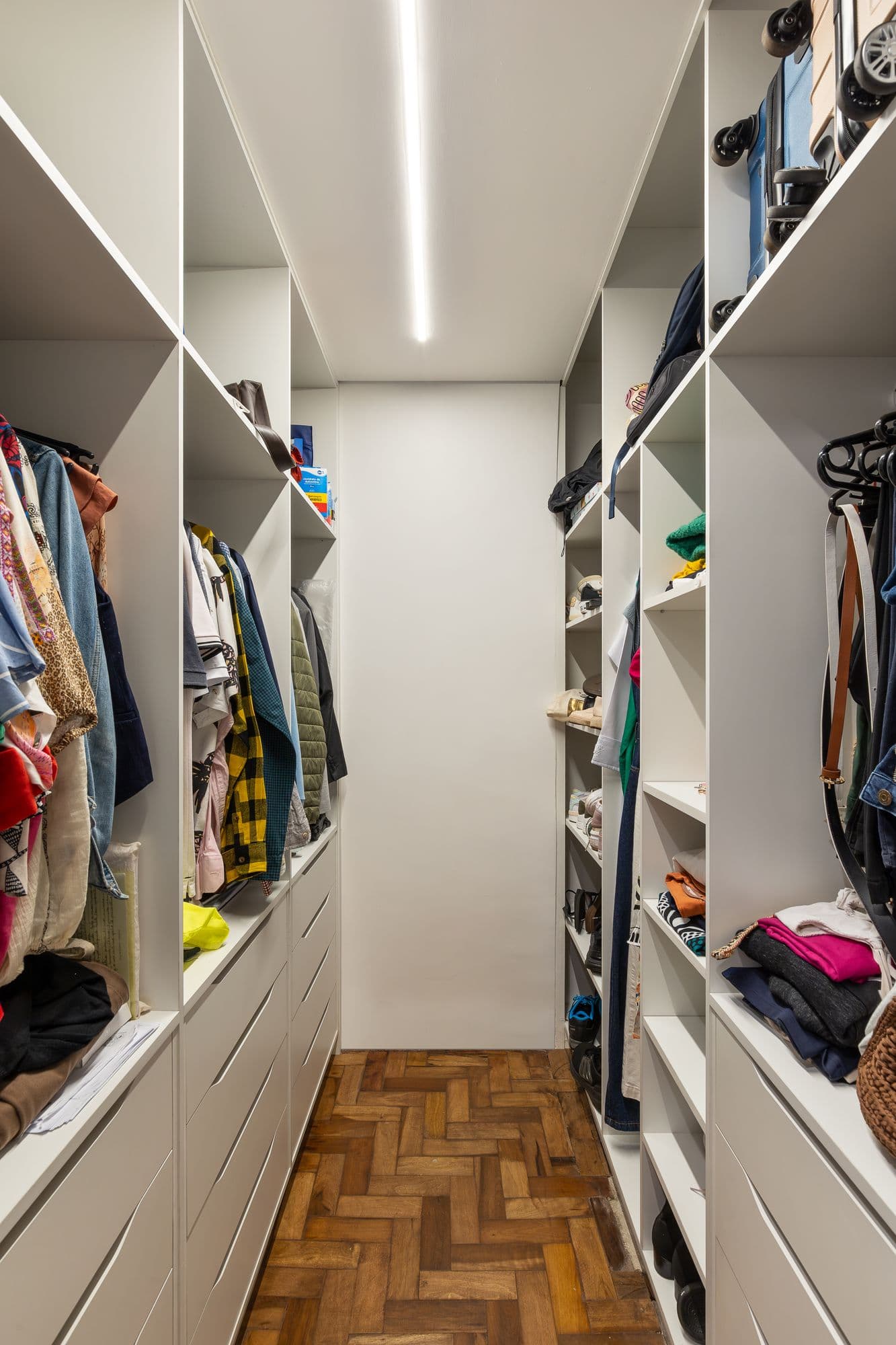 Closet com prateleiras e cabideiros dos dois lados