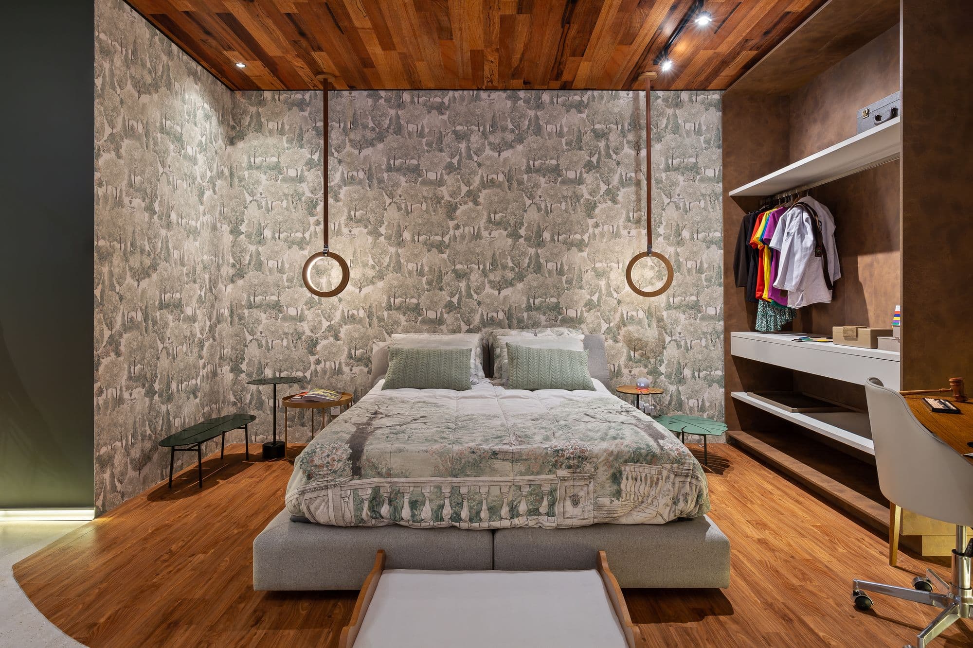Dormitório com parede de pedra, cama central e closet aberto