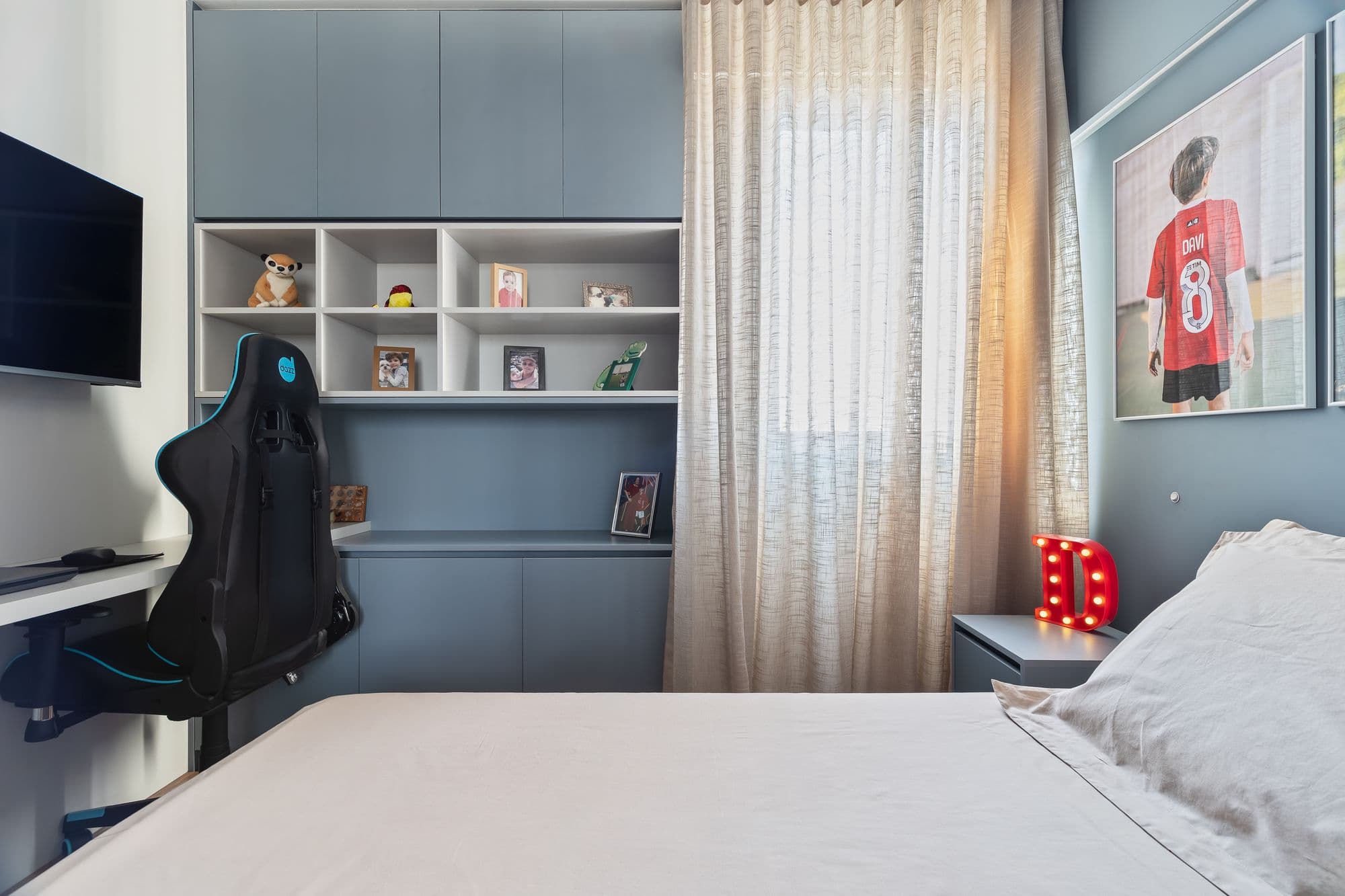 Quarto juvenil com bancada de estudos e estante de nichos