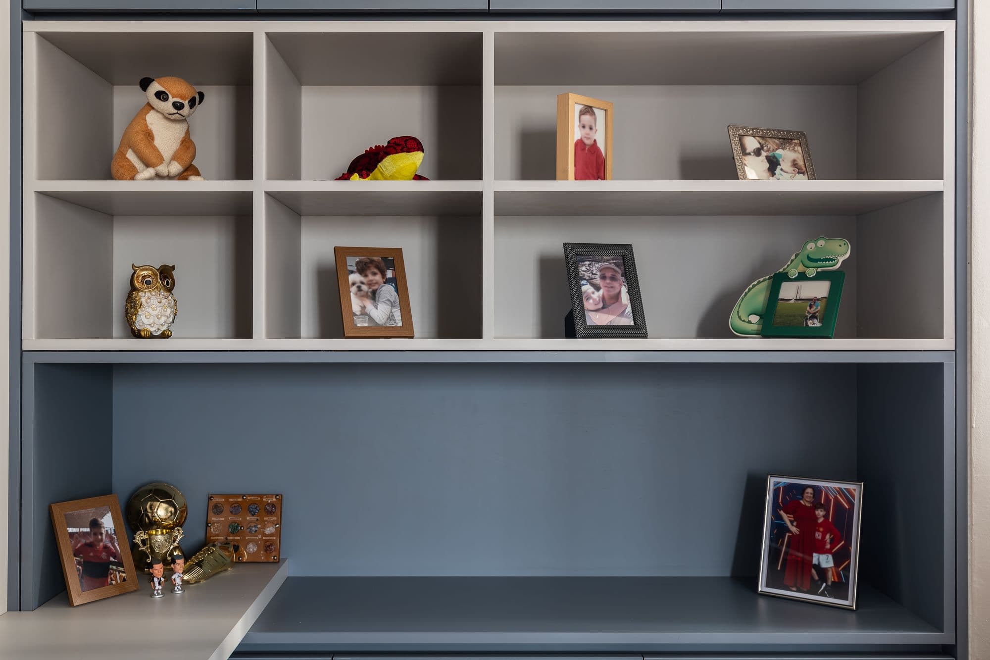 Estante de nichos com fotos e objetos sobre a bancada